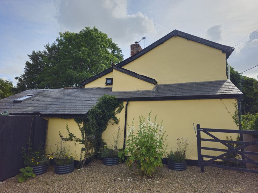 Cream rendered cottage and its outbuilding